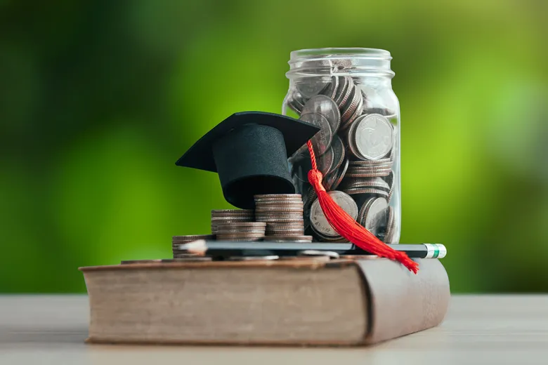 A book, mortarboard, and pennybank
