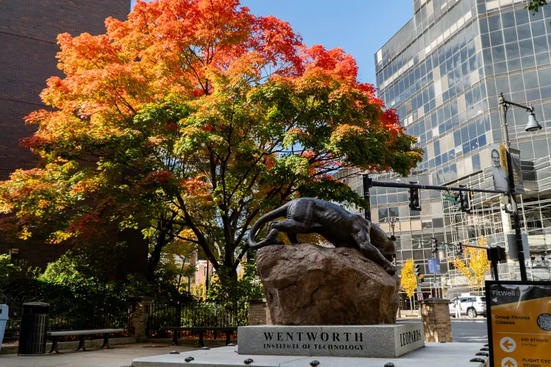 Leopard statue on a street in the fall foliage