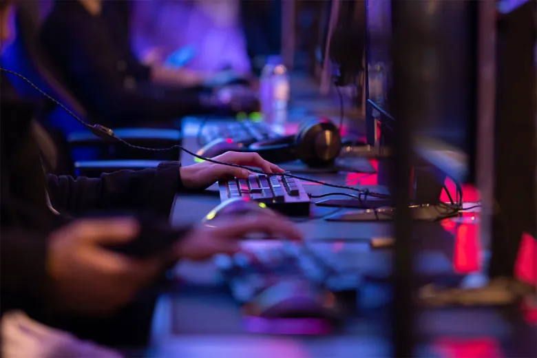 Students sit at computer gaming setups and playing an online game