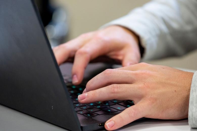 hands typing on a laptop keyboard