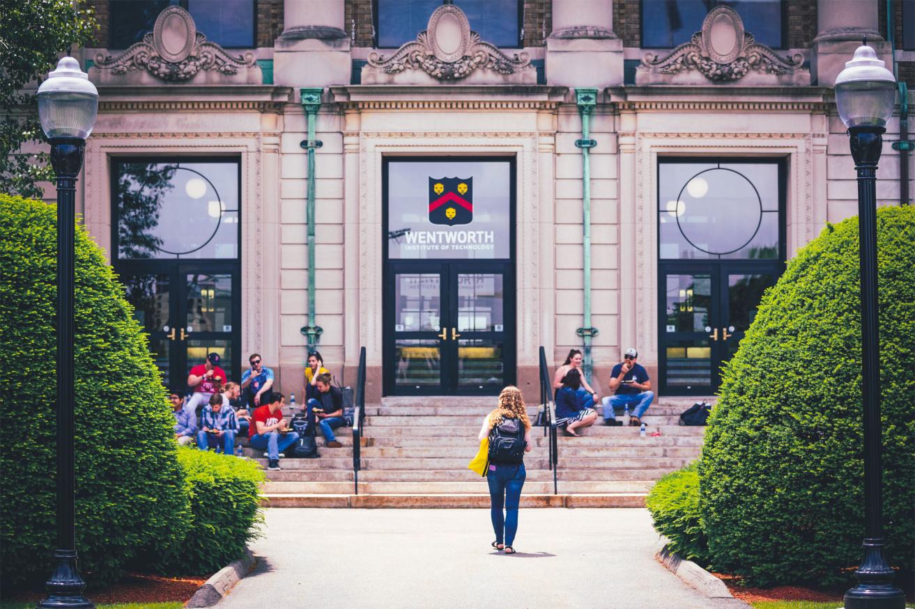 A student walks towards the front of Wentworth hall