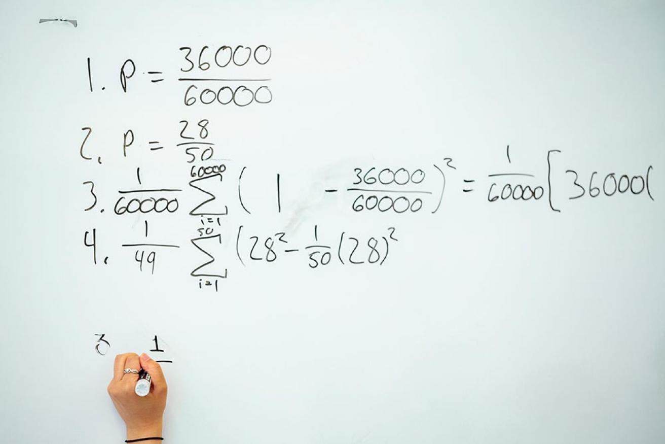 Math equation written on whiteboard