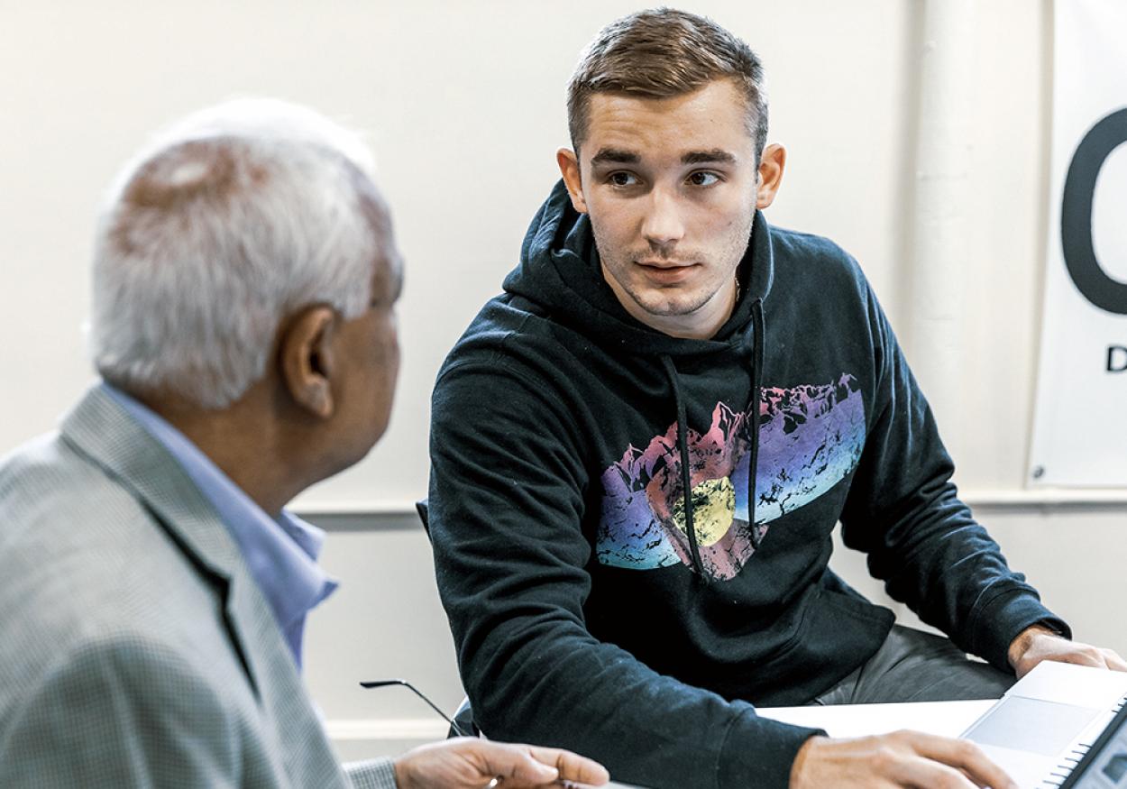 A male student talks to a professor