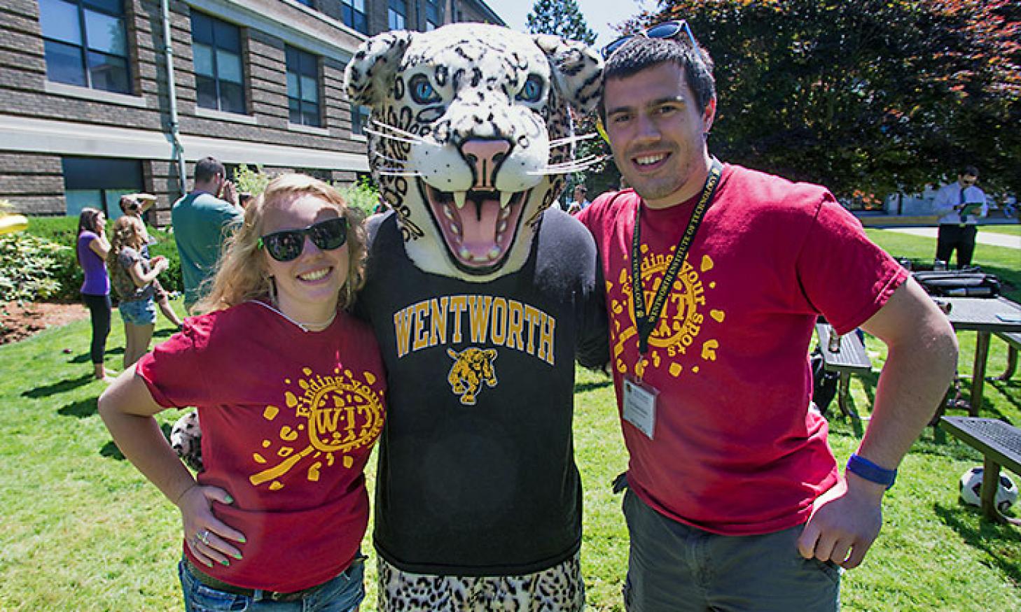 A female and male student pose on the Quad with the leopard mascot.