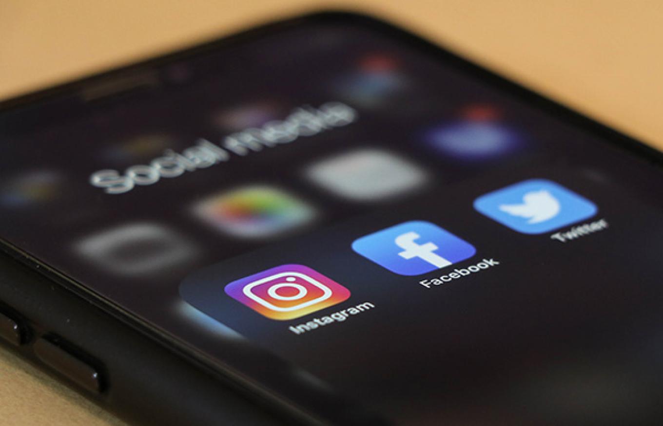 Stock photo of a cell phone displaying social media icons.
