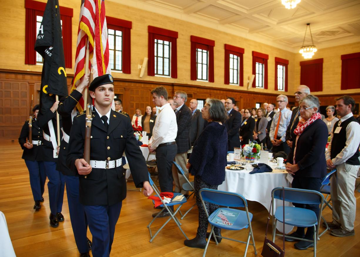 Military Color Guard Carry Flags While Lunch Attendees Look On