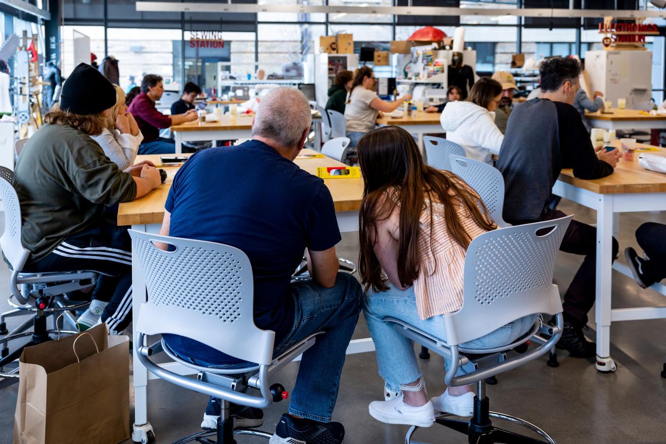 A father and daughter sit in an information session