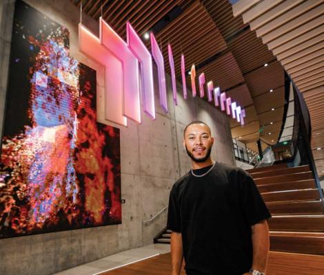 man standing in front of illuminated art installation
