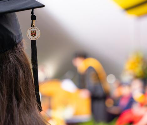 Image of a graduation cap and tassel with a woman with long dark hair