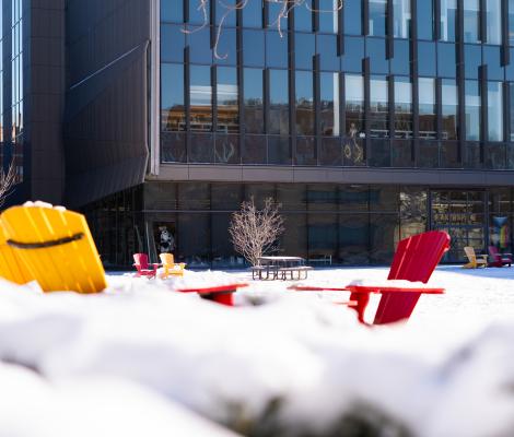 colorful chairs on the snow in front of a modern looking building