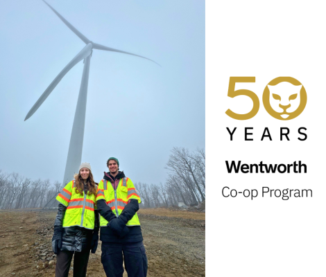 two students in front of a wind turbine