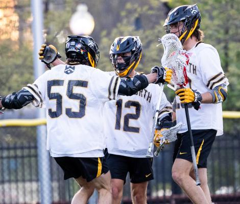 lacrosse players on a field congratulate each other