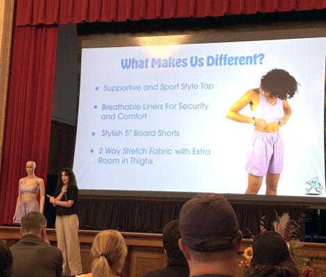 a woman presents swimwear designs to an audience