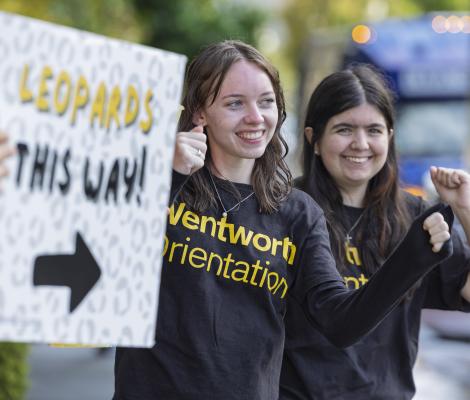 a woman holds up a welcoming sign