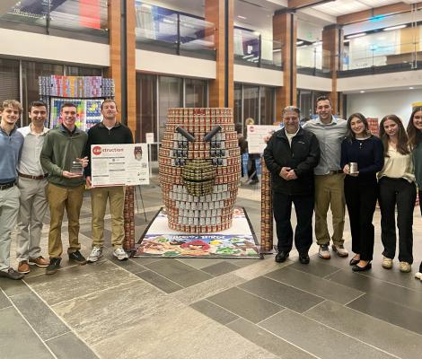 a large installation of cans sits next to a group of students