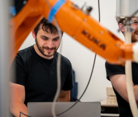 people smiling near a robotic arm