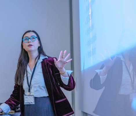 a woman speaking in front of a projection
