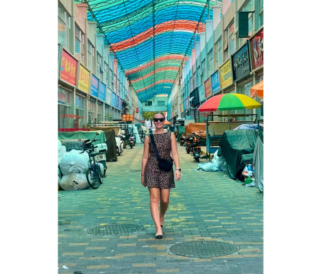 a woman walking down a colorful street
