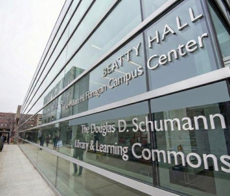 people walking past a glass building outside