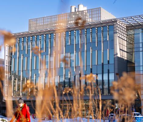 a modern building as seen through some winter grass