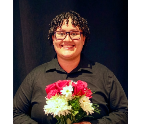 a smiling woman holds flowers