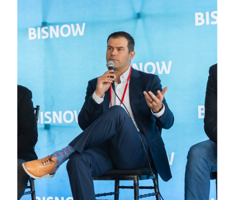 a man speaking on stage with a microphone