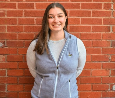 a woman standing in front of a brick wall