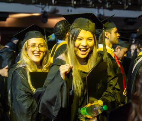 very happy students in graduation robes