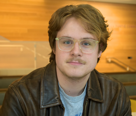 portrait of a man wearing glasses and a leather jacket
