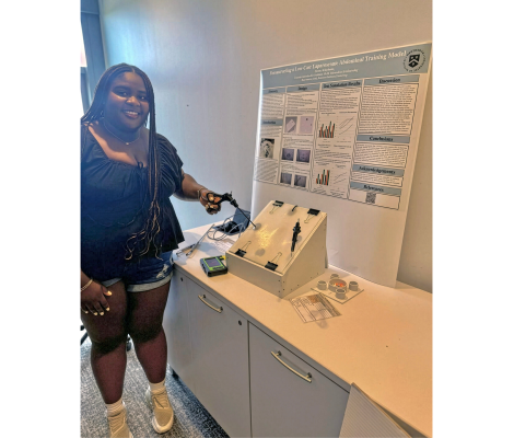 a woman poses with a medical device she created