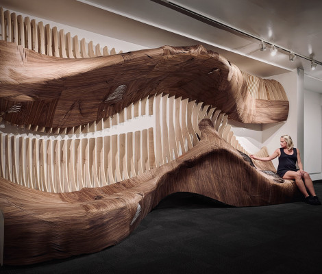 a woman poses near an art installation