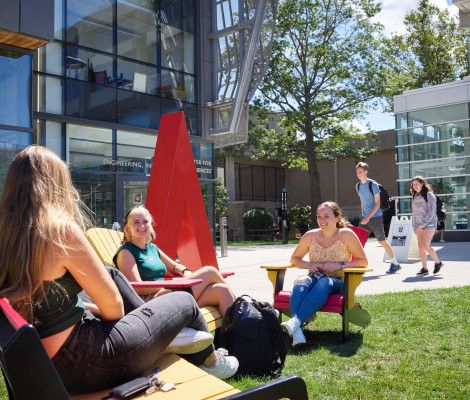 a group of students hanging out on a grassy quad