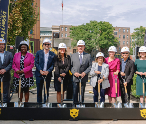 a group of people wearing hard hats and holding shovels