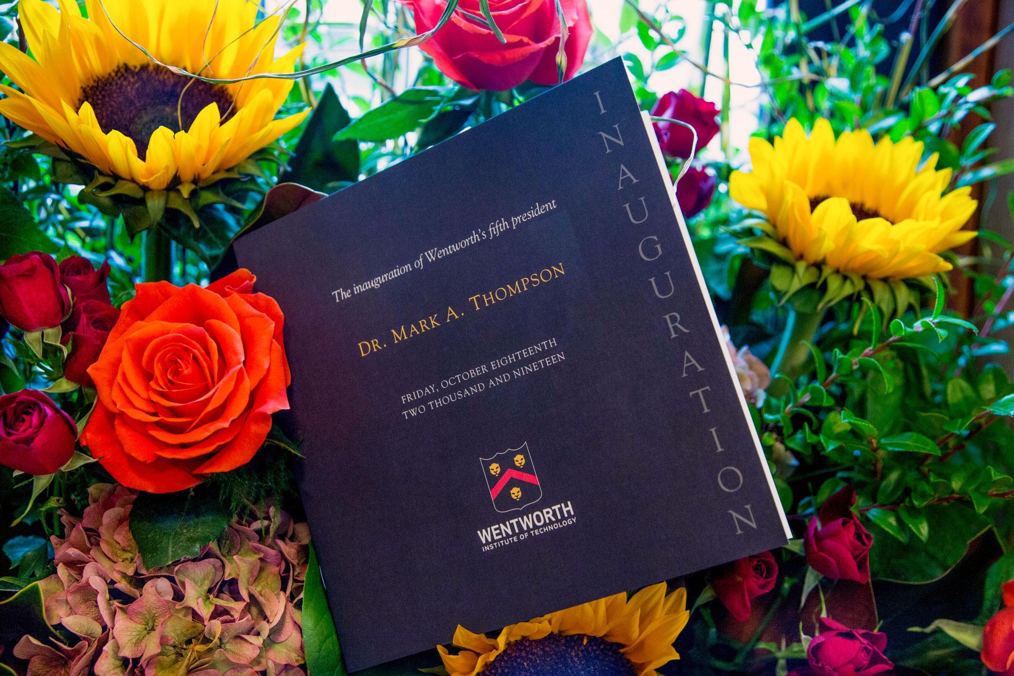 A photo of the inauguration program placed in a flower arrangement