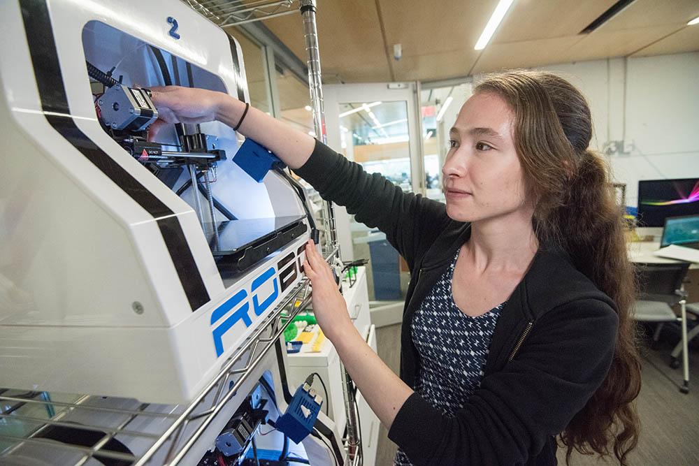Student working with engineering machinery in a lab