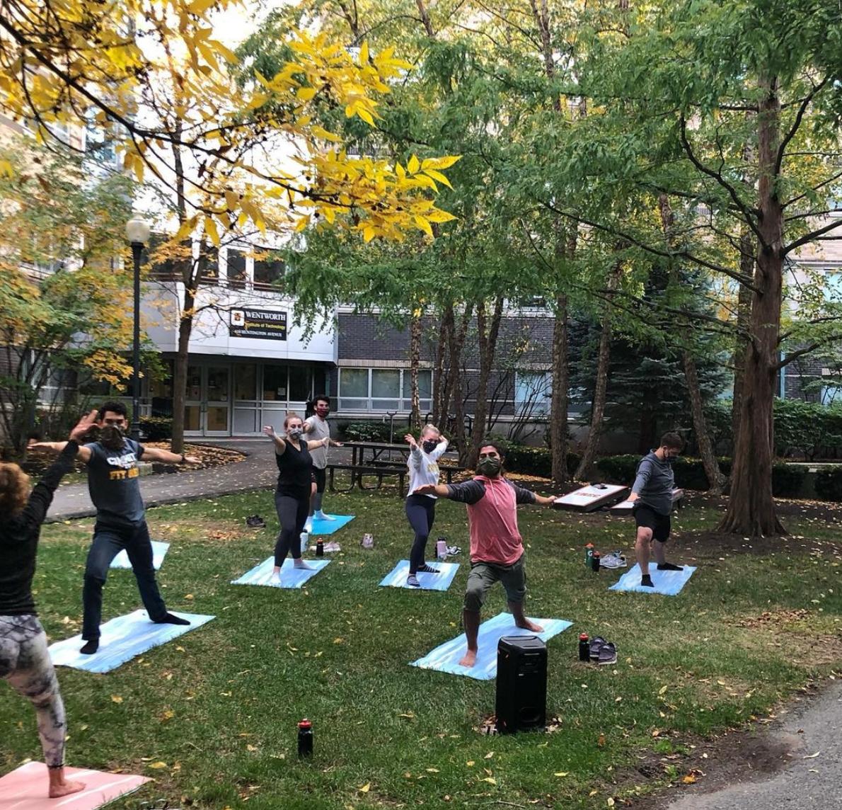 people doing yoga outside while wearing masks