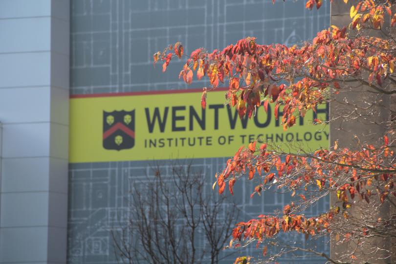 orange autumn leaves in front of a yellow Wentworth sign