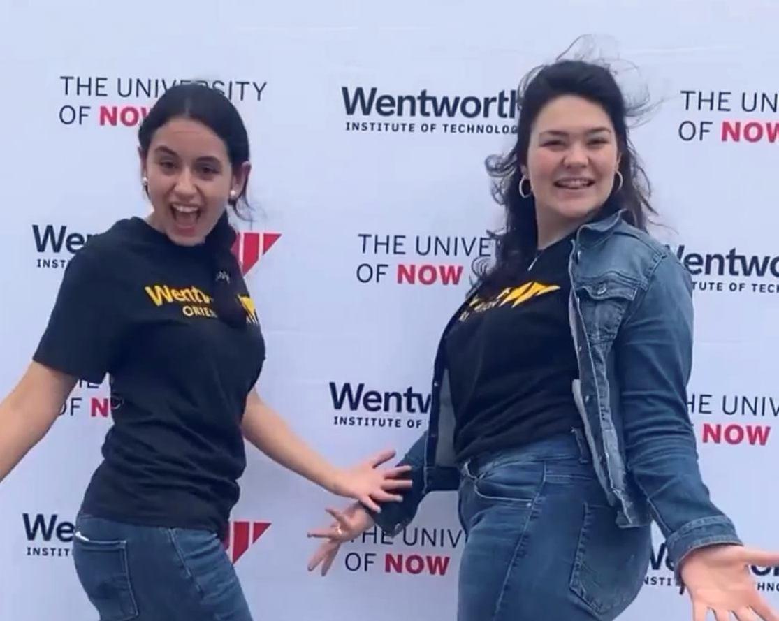 students facing camera and posing with hands out