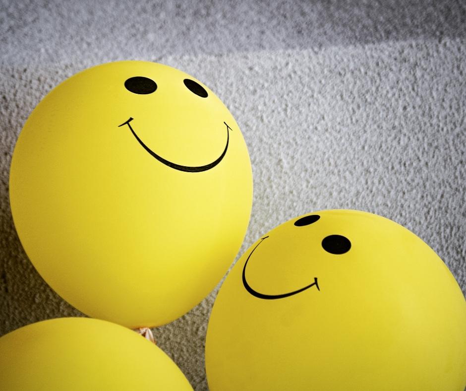yellow balloons with smiley faces drawn on