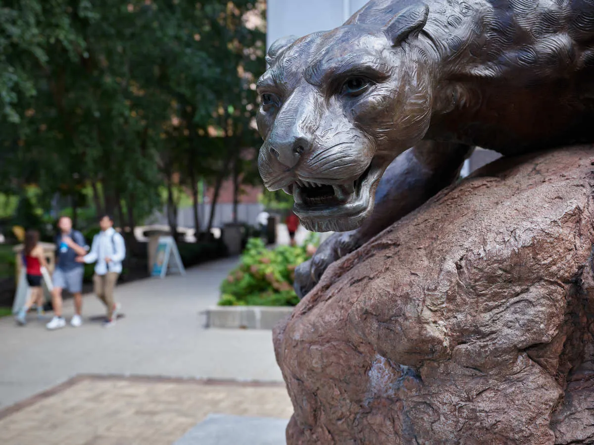 Statue of the Wentworth Leopoard in the foreground and students walking in the background