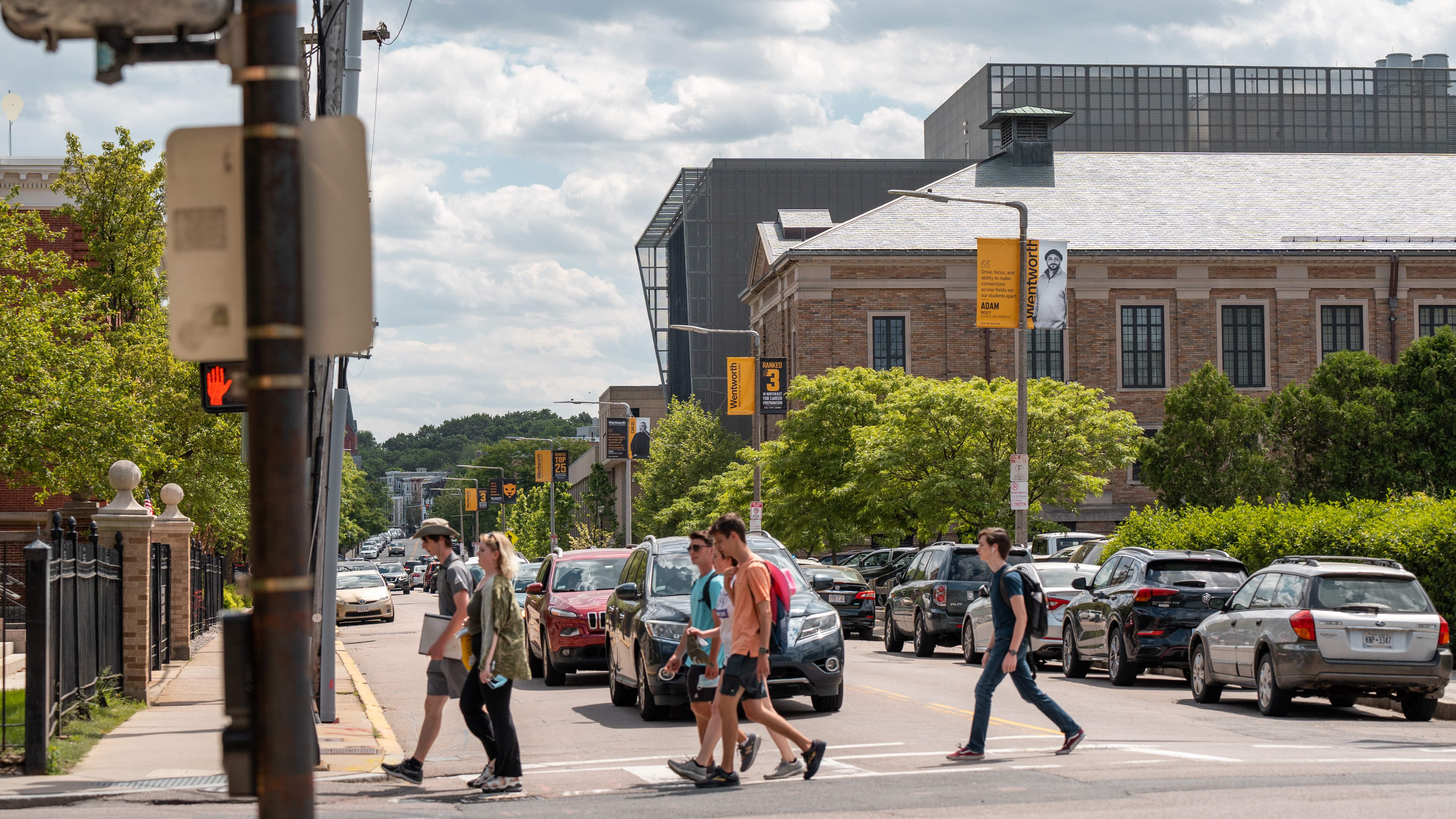 people walking across a street in summer