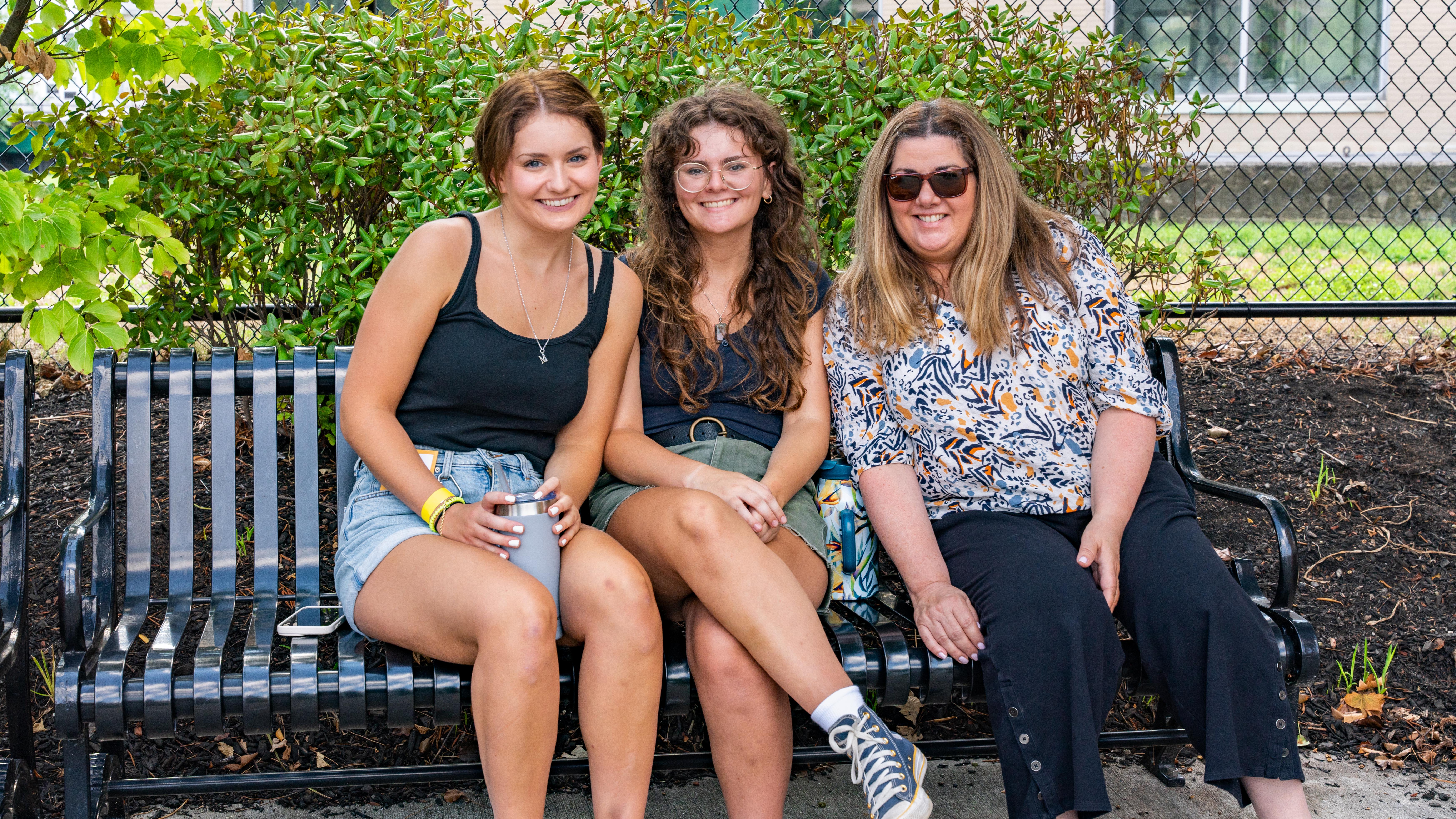 three women sitting on a bench