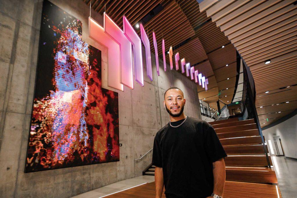 man standing in front of illuminated art installation