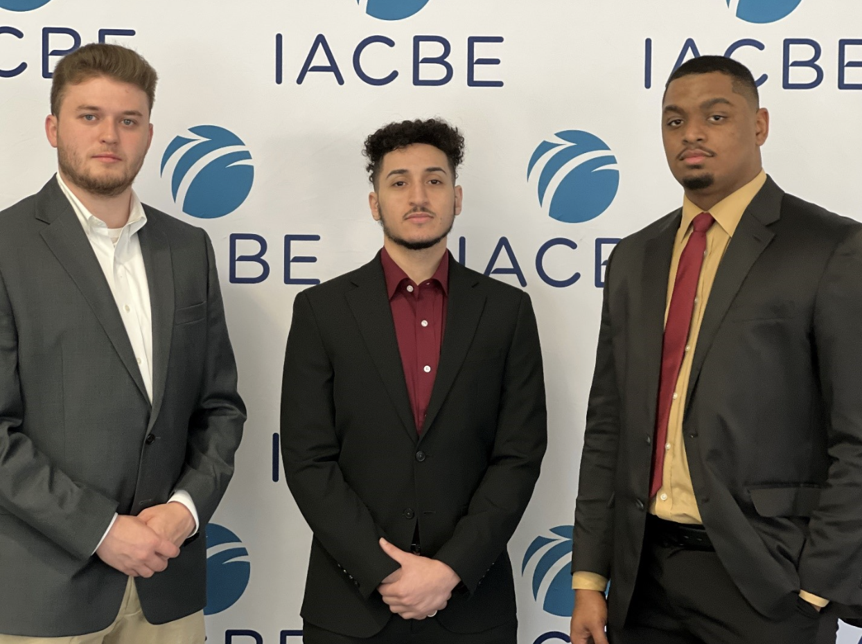 three students pose for camera