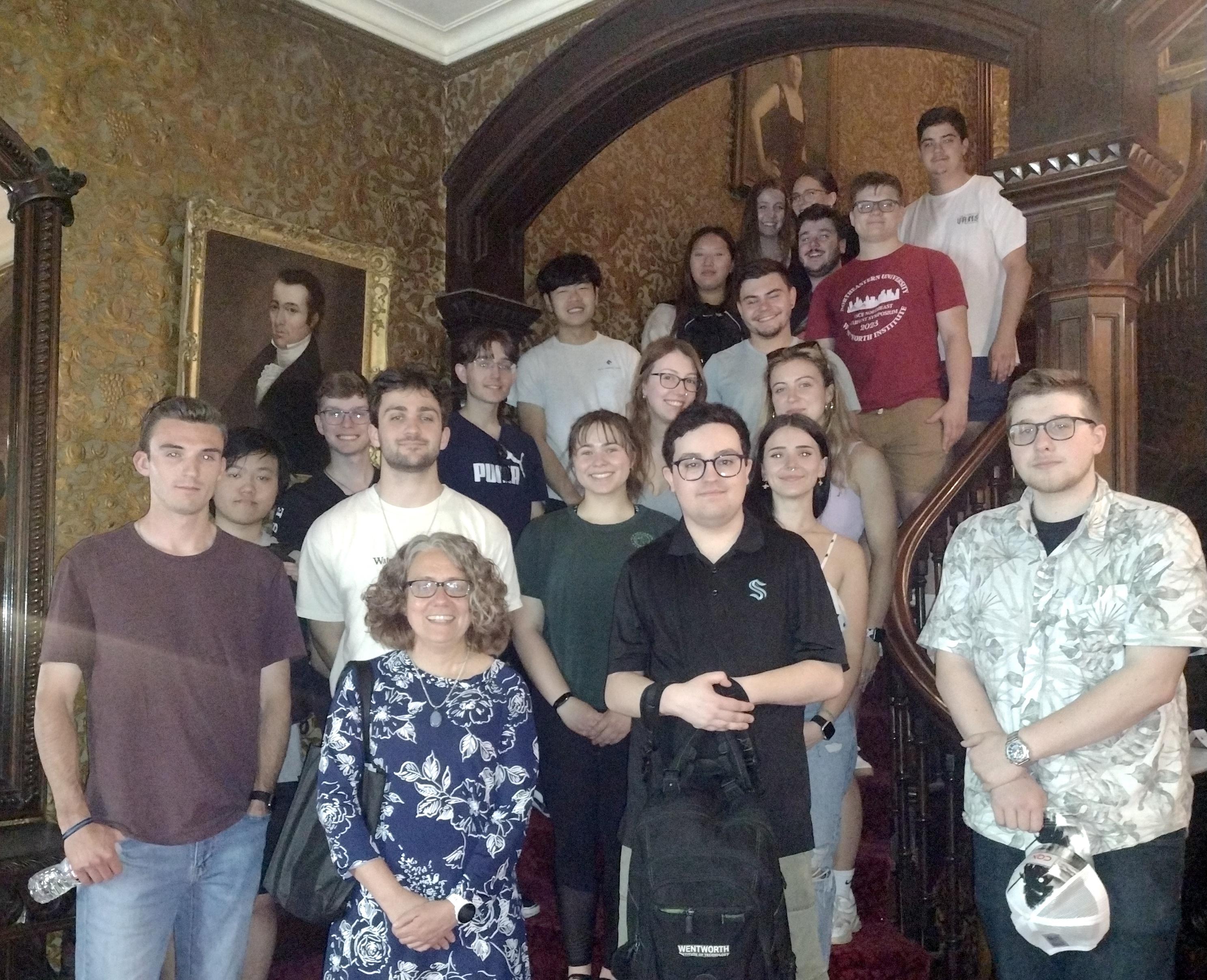 group of people posed around a historic staircase