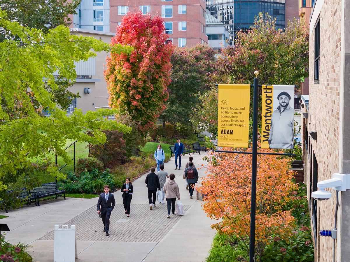 Students walking on the sidewalk that extends from the dorms to campus