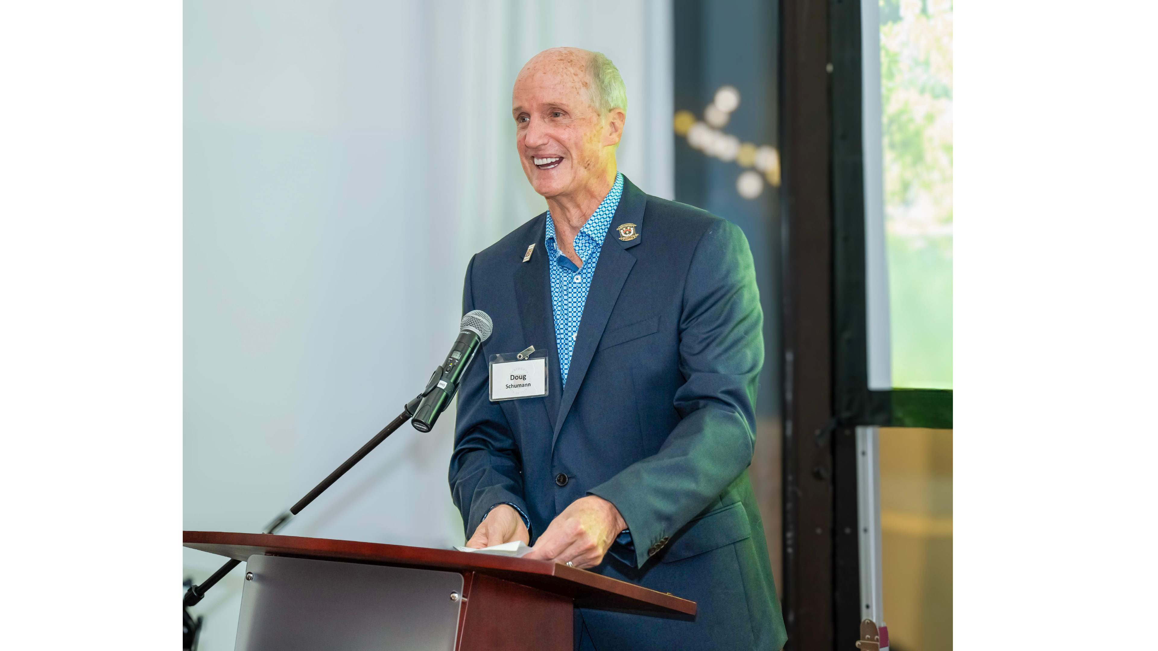 a man smiles at a podium