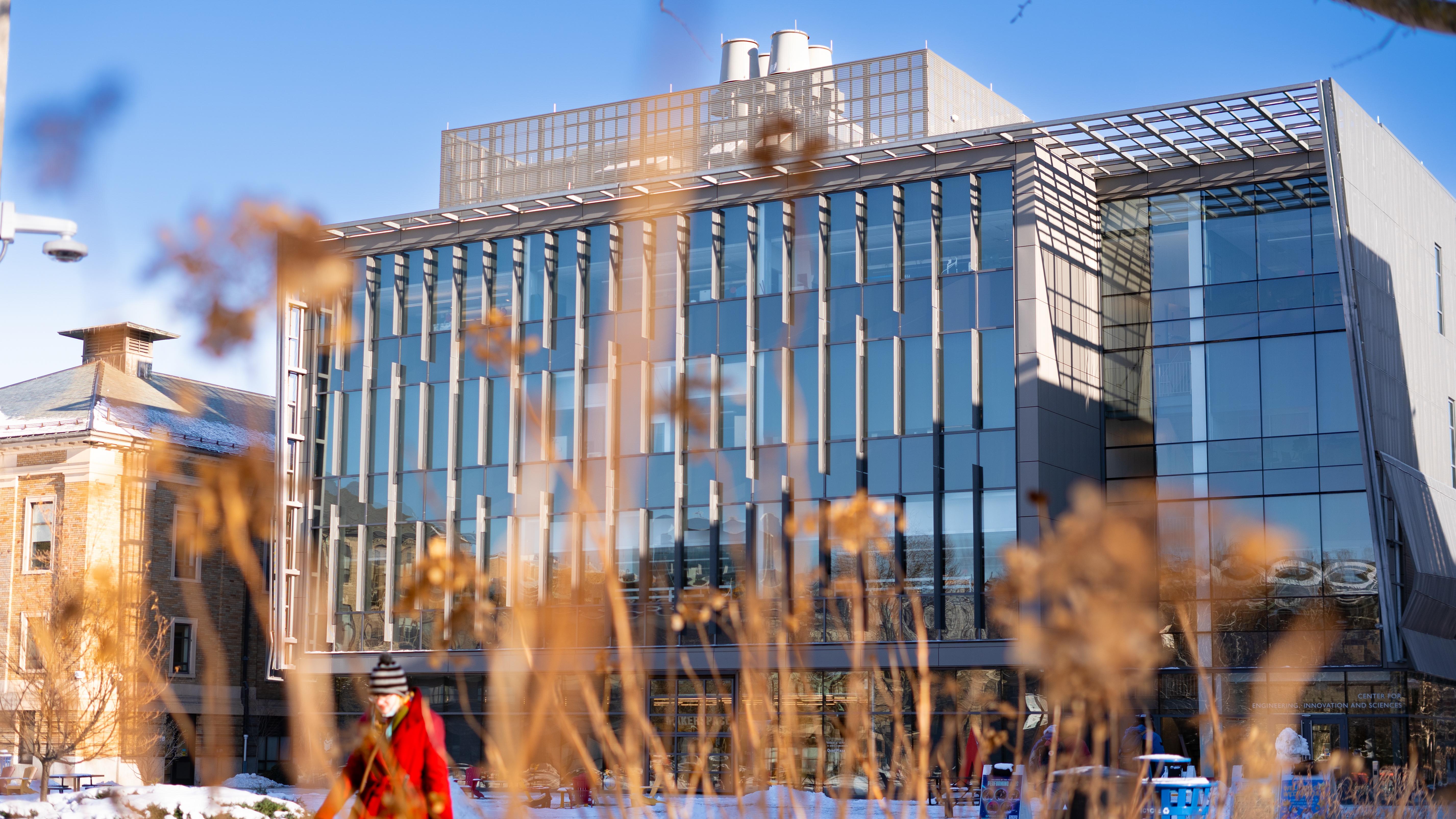 a modern building as seen through some winter grass