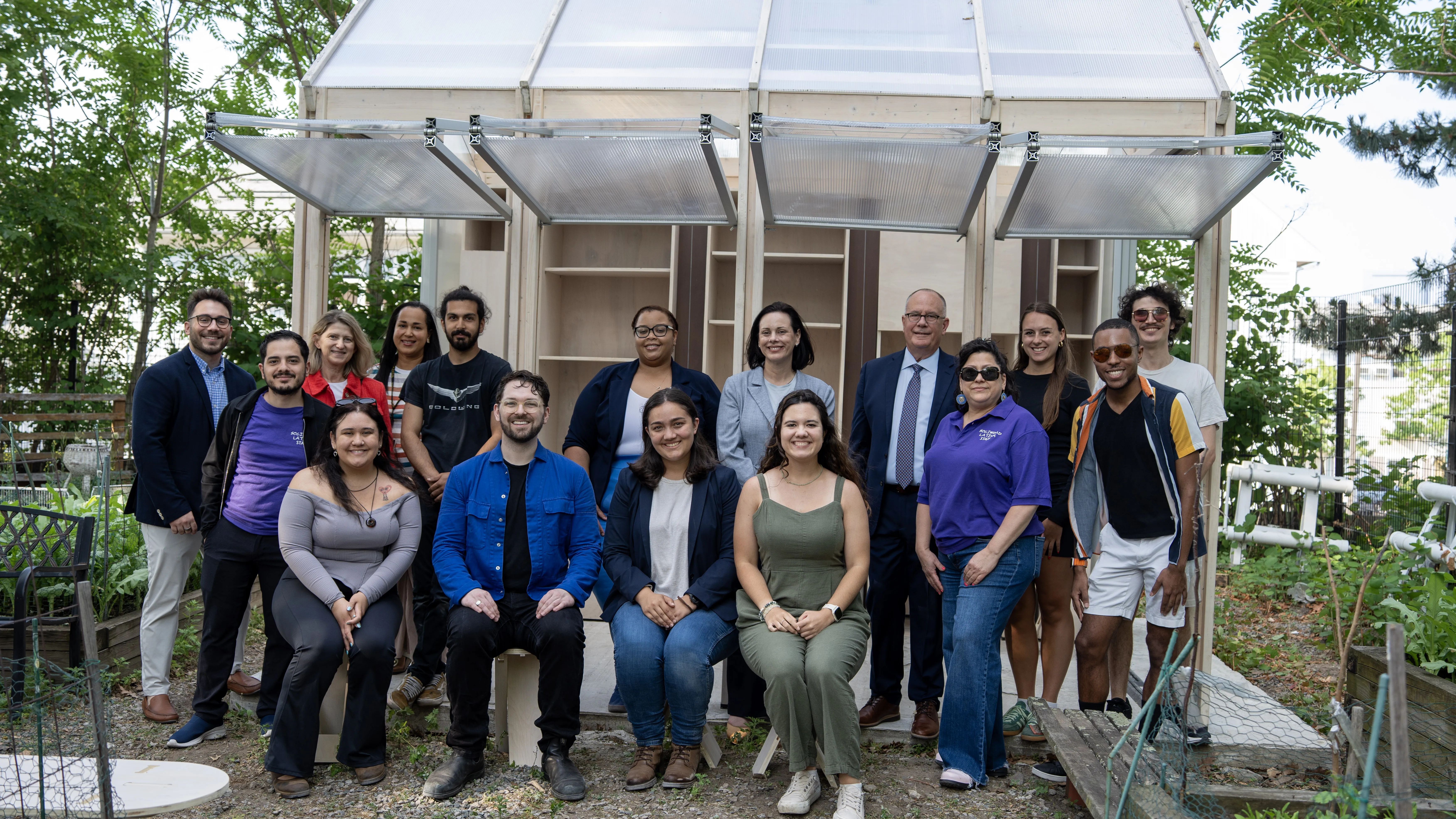 large group of people posing in a garden together