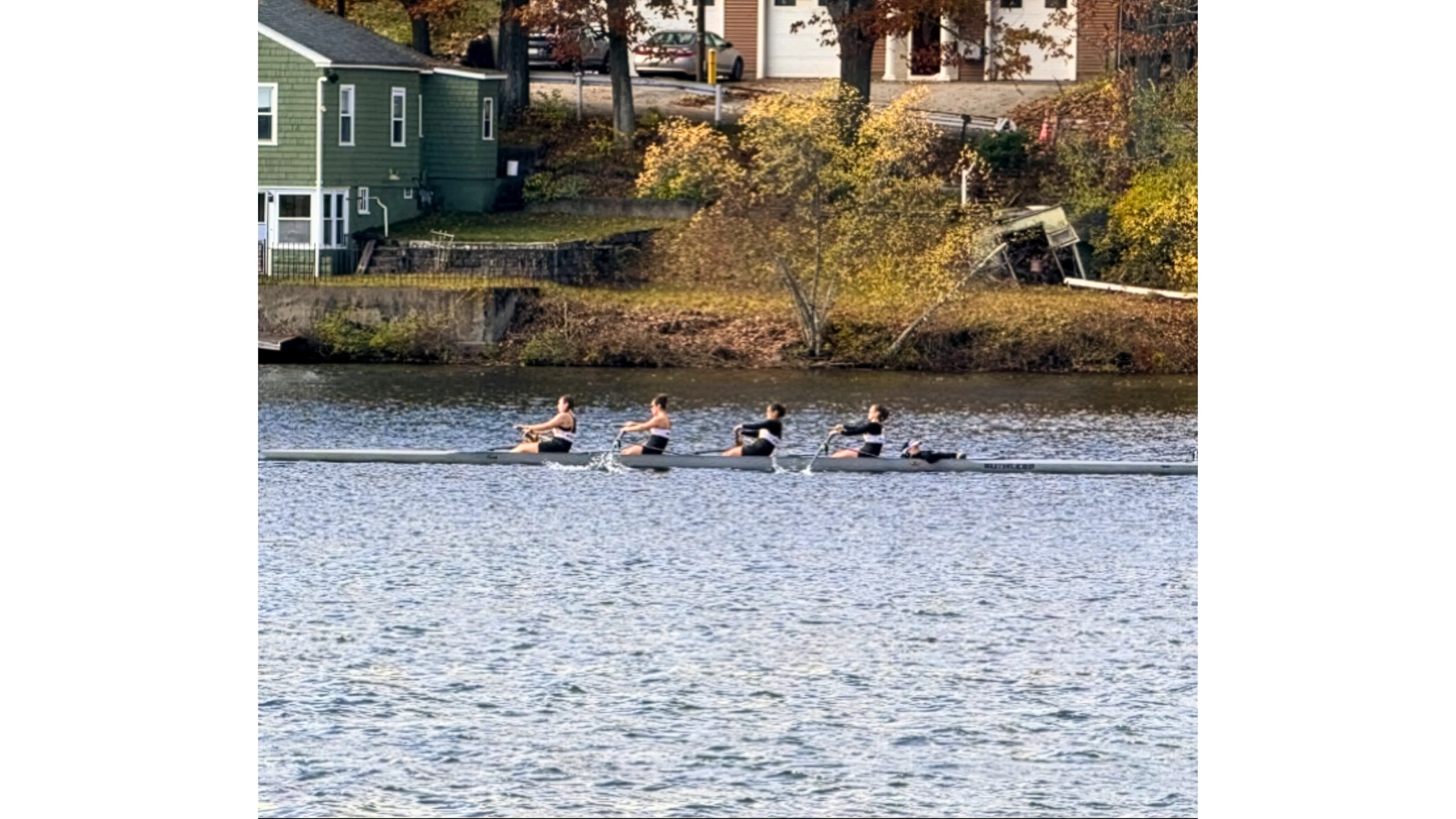 four women in a boat rowing on the river